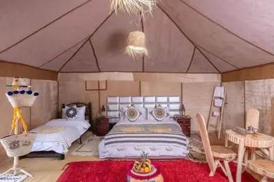 a bedroom with two beds in a tent at Overnight luxury camp merzouga in Merzouga