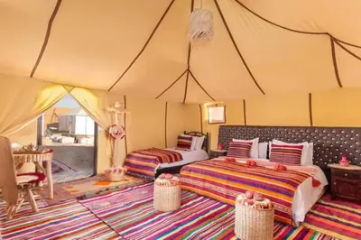 a bedroom with two beds in a tent at Overnight luxury camp merzouga in Merzouga