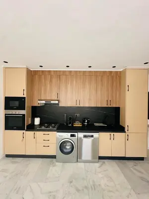 a kitchen with wooden cabinets and a washing machine at 1 Bedroom Apartment Rooftop Pool Marrakech in Oulad Akkou