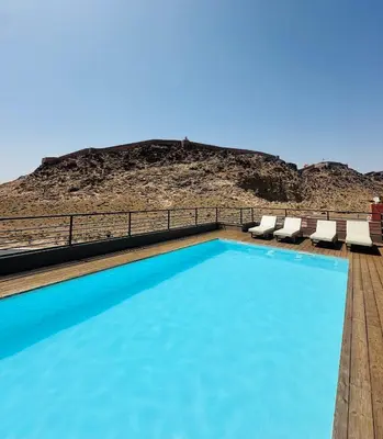 a swimming pool with chairs and a mountain in the background at 1 Bedroom Apartment Rooftop Pool Marrakech in Oulad Akkou