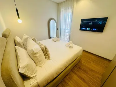 a large bed in a room with a tv on the wall at 1 Bedroom Apartment Rooftop Pool Marrakech in Oulad Akkou