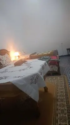 a bedroom with a bed with white sheets and a lamp at Casa caram in Hassilabied