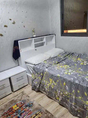 a bedroom with a bed with a comforter at Appartement de luxe in Meknès