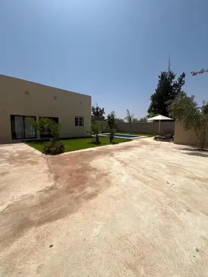 a large dirt driveway in front of a building at Maison Royale in Douar bel Rhanodour