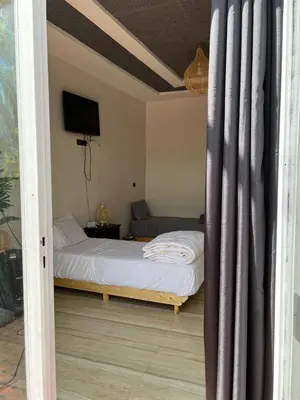 a bedroom with a bed and a television in it at Chambre d'hôtes dans luxueuse villa avec piscine in Had Abdallah Rhiat