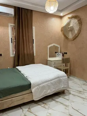 a bedroom with a bed and a table and a mirror at Chambre d'hôtes dans luxueuse villa avec piscine in Had Abdallah Rhiat
