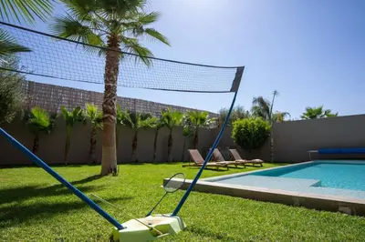 a volley ball net in a yard next to a pool at Villa Seyana 3 sans vis a vis, Piscine Chauffee in Marrakech