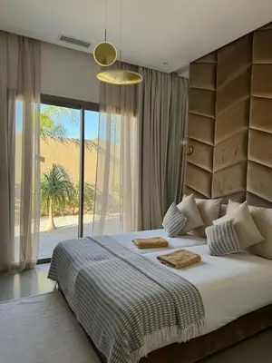 a bedroom with a large bed and a large window at Villa Seyana 4 sans vis a vis, Piscine Chauffee in Marrakech