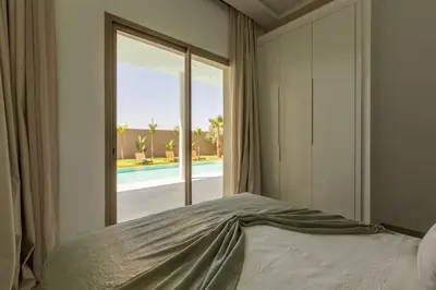 a bedroom with a bed and a view of a pool at Villa Seyana 4 sans vis a vis, Piscine Chauffee in Marrakech