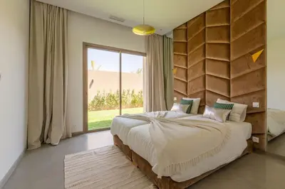 a bedroom with a large bed and a large window at Villa Seyana 4 sans vis a vis, Piscine Chauffee in Marrakech
