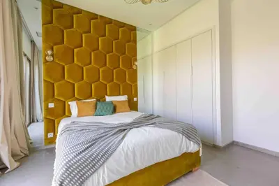 a bedroom with a large bed with a yellow headboard at Villa Seyana 4 sans vis a vis, Piscine Chauffee in Marrakech