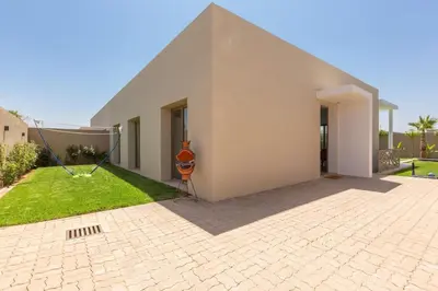a large white house with a lawn in front of it at Villa Seyana 4 sans vis a vis, Piscine Chauffee in Marrakech