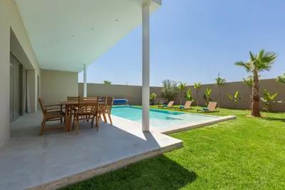 a patio with a table and chairs next to a swimming pool at Villa Seyana 4 sans vis a vis, Piscine Chauffee in Marrakech