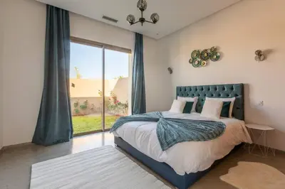 a bedroom with a bed and a large window at Villa Seyana 6 Zero vis a vis Piscine chauffee in Marrakech