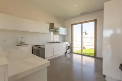 a kitchen with white appliances and a large window at Villa Seyana 6 Zero vis a vis Piscine chauffee in Marrakech