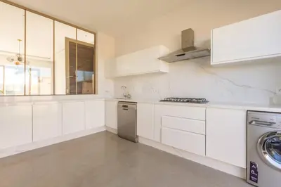 a kitchen with white cabinets and a washer at Villa Seyana 6 Zero vis a vis Piscine chauffee in Marrakech