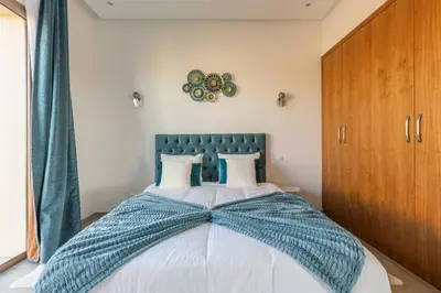 a bedroom with a large bed with a blue headboard at Villa Seyana 6 Zero vis a vis Piscine chauffee in Marrakech