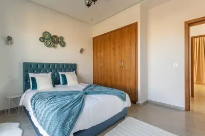 a bedroom with a large bed with a blue headboard at Villa Seyana 6 Zero vis a vis Piscine chauffee in Marrakech