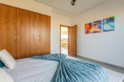 a bedroom with a bed with a blue blanket on it at Villa Seyana 6 Zero vis a vis Piscine chauffee in Marrakech