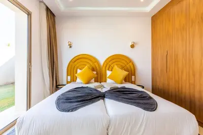 a bedroom with a large bed with a bow tie on it at Villa Seyana 7 Zero Vis a Vis, Piscine Chauffee in Gzoula