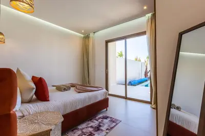 a bedroom with a bed and a view of a pool at Villa Seyana 7 Zero Vis a Vis, Piscine Chauffee in Gzoula