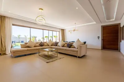 a living room with a couch and a table at Villa Seyana 7 Zero Vis a Vis, Piscine Chauffee in Gzoula