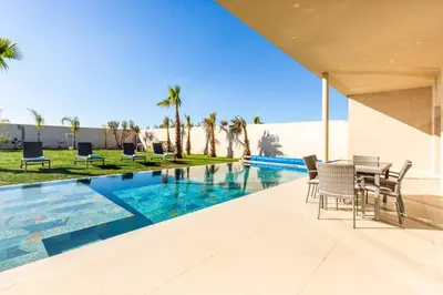 a villa with a swimming pool and a table and chairs at Villa Seyana 8 Zero Vis a Vis Piscine Chauffee in Gzoula