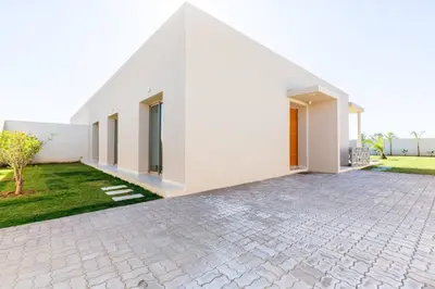 a white house with a stone driveway at Villa Seyana 8 Zero Vis a Vis Piscine Chauffee in Gzoula