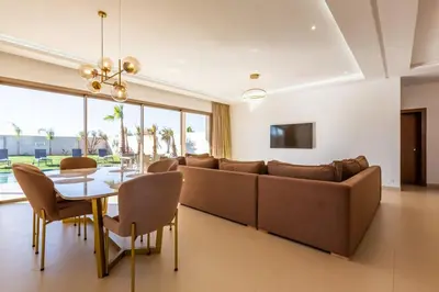 a living room with a couch and a table and chairs at Villa Seyana 8 Zero Vis a Vis Piscine Chauffee in Gzoula