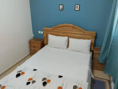 a bedroom with a bed with a wooden headboard at Appartement bien équipé in Ifrane