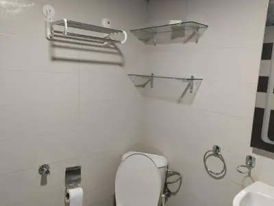 a white bathroom with a toilet and a sink at Appartement bien équipé in Ifrane