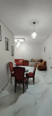 a living room with a table and chairs and a couch at Good life in Fès