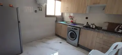 a small kitchen with a washing machine in it at Good life in Fès