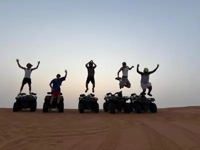 a group of people jumping in the desert on atvs at chez zakaria luxury tent camp merzouga in Merzouga