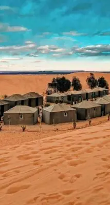 a group of buildings in the middle of a desert at chez zakaria luxury tent camp merzouga in Merzouga