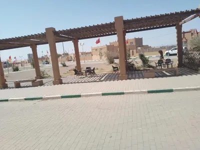 a pavilion with tables and benches in a parking lot at chez zakaria luxury tent camp merzouga in Merzouga