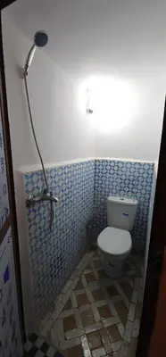 a bathroom with a toilet in a blue tiled bathroom at The hostel with terrace view in Fès