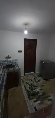a room with a bed and a television and a door at The hostel with terrace view in Fès