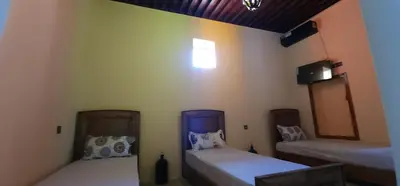 a room with two beds and a television in it at The hostel with terrace view in Fès