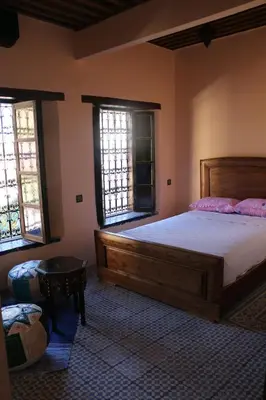 a bedroom with a large bed and two windows at The hostel with terrace view in Fès