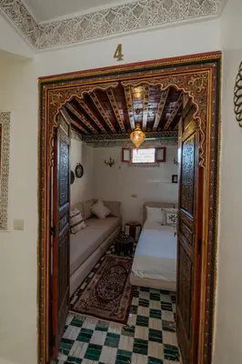 a room with a bed and an open door at Riad Qobbat Zaouïa in Fès