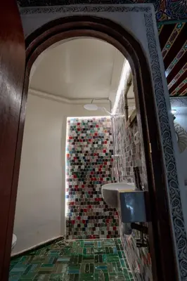 a bathroom with a sink and a mosaic wall at Riad Qobbat Zaouïa in Fès