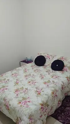 a bed with a floral bedspread with two pillows on it at 2 bedroom apartment for rent in Meknès