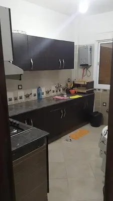 a kitchen with black cabinets and a counter top at 2 bedroom apartment for rent in Meknès