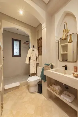 a bathroom with a toilet and a sink and a mirror at Villa AIMA - avec Gourvernante in Douar Soukkane
