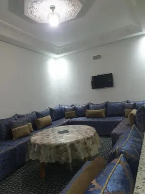 a living room with a blue couch and a table at Charmant appart proche Ain Asserdoun Béni Mellal in Oulad Akkou
