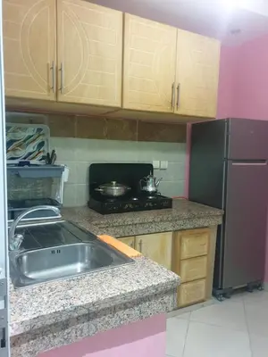 a kitchen with a sink and a refrigerator and a stove at Charmant appart proche Ain Asserdoun Béni Mellal in Oulad Akkou