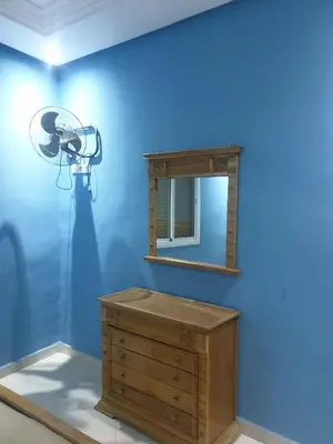 a blue room with a dresser and a mirror at Charmant appart proche Ain Asserdoun Béni Mellal in Oulad Akkou