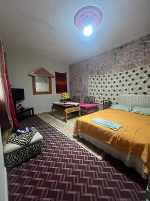 a bedroom with a bed and a table in it at Gite taymate in Zaouia Ben Smine