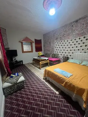 a bedroom with a bed and a couch in it at Gite taymate in Zaouia Ben Smine